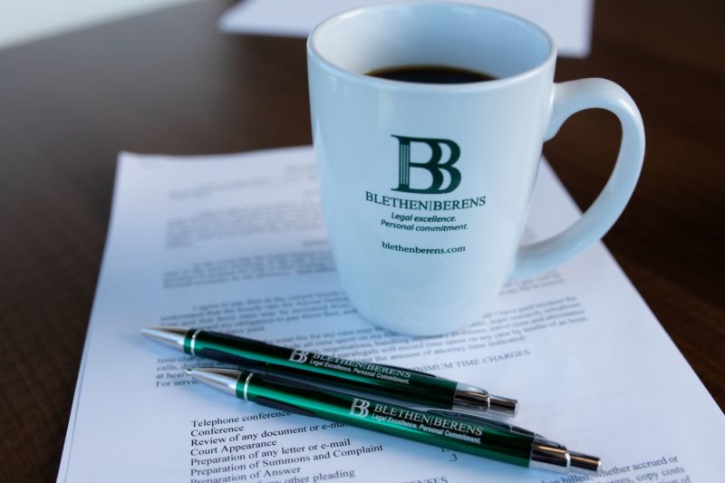 Business Disputes: contract with pens and coffee cup.
